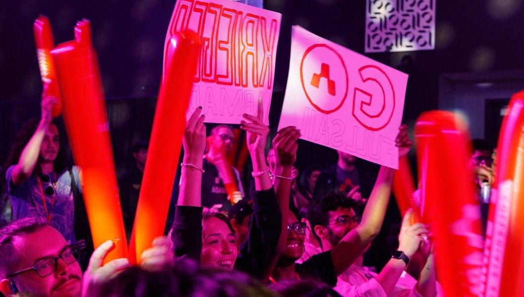 A crowd of people waving orange thunder sticks with the 无敌舰队 logo 和 signs that read “Go Krieger”.